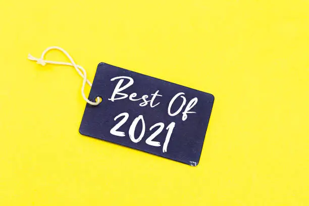 Photo of tag with best of 2021 isolated on yellow background