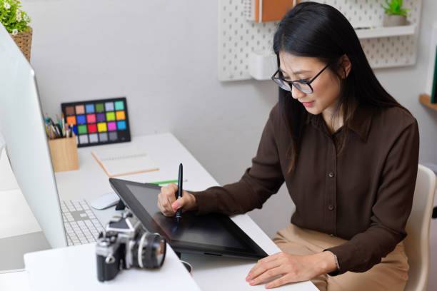 istock Female designer working with drawing tablet on computer desk in office room 1310409446