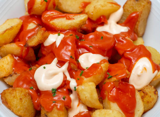 Closeup of a serving of Spanish spicy potatoes Closeup of a serving of Spanish spicy potatoes in a fancy restaurant patatas bravas stock pictures, royalty-free photos & images