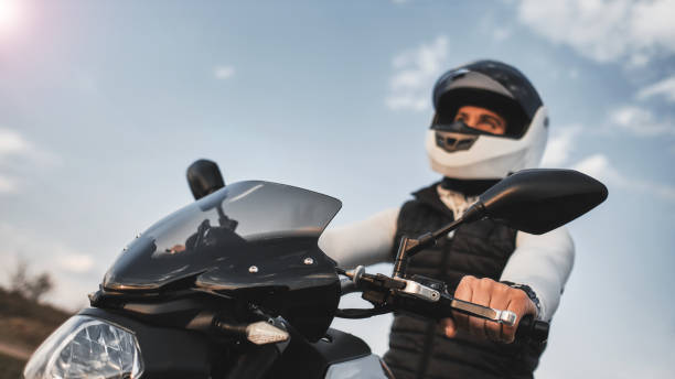 retrato de um jovem andando de moto e usando um capacete. - motorcycle handlebar road riding - fotografias e filmes do acervo