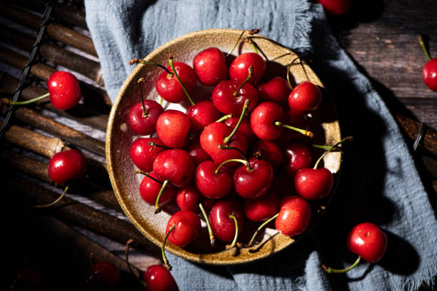 istock Fresh cherry fruit in plate on wooden background 1310414456