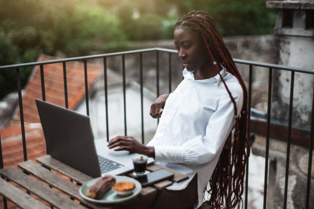 屋外でラップトップを使用してアフリカの女性 - braids african descent women pensive ストックフォトと画像