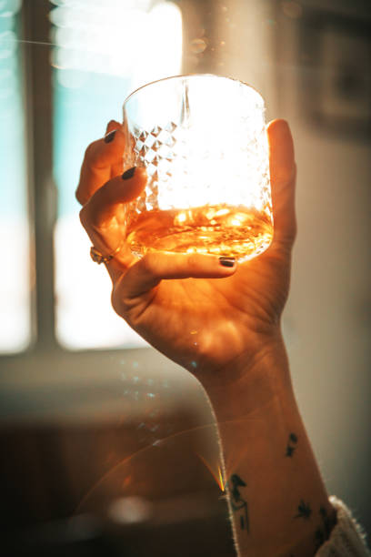 istock Women hand holding an alcoholic drink backlit sun 1310415650