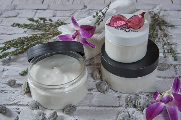 istock Two handmade cream jars decorated with aromatic herbs and apricot pits. 1310415742