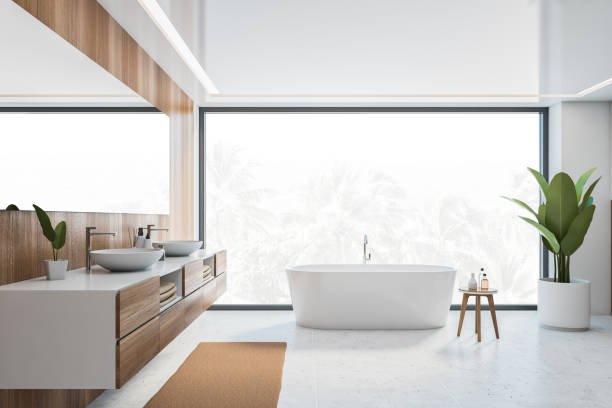 istock Wooden and white bathroom with white bathtub, sinks and window 1310418789