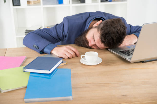 istock energy and tiredness. boss fell asleep on table. Man sleep over workplace. coffee will help. bored and exhausted guy sleep at work. need break for relax. being lazy. Tired businessman sleep in office 1310420841