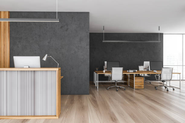 istock Wooden reception room desk with computers and open space office room 1310421537