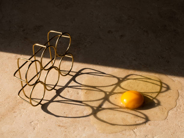istock Raw egg on a beige table. Harsh shadows fall from the egg tray. Healthy food concept 1310421644