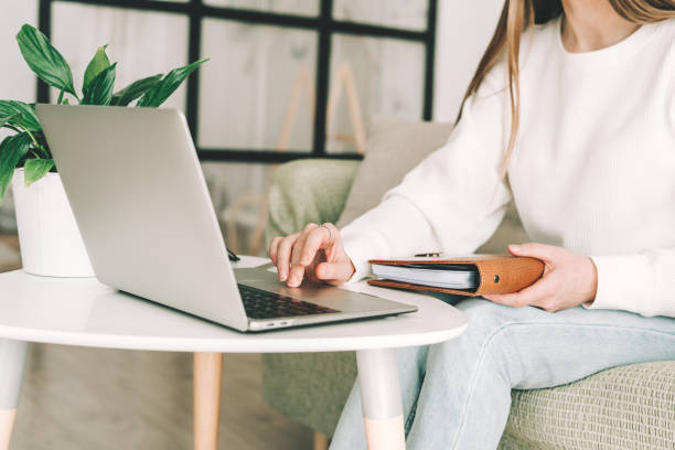 istock Woman writes in notebook with laptop 1310422099