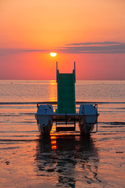 pedal boat on the beach during amazing ocean sunrise at Rivazzurra (Rimini / Italy) pedal boat on the beach during amazing ocean sunrise at Rivazzurra (Rimini / Italy) pedal boat stock pictures, royalty-free photos & images