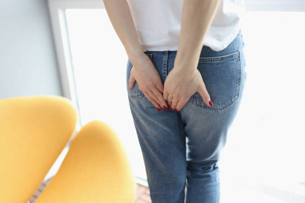 istock Woman stands and embarrassedly holds her hands on her buttocks 1310422789