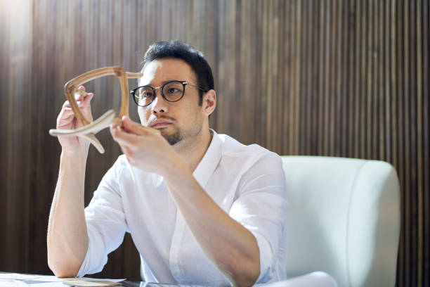 istock Asian bearded designer sitting, thinking and sketching ideas indoors 1310423813