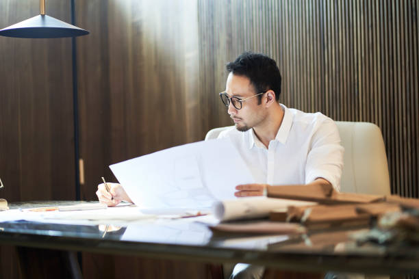 istock Asian bearded designer sitting, thinking and sketching ideas indoors 1310423865