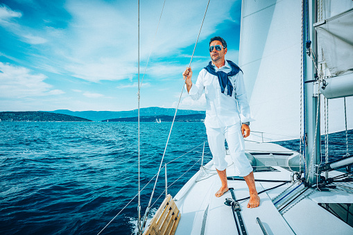 Handsome man sailing with sailboat.