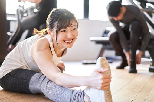 Asian woman stretching in a training gym