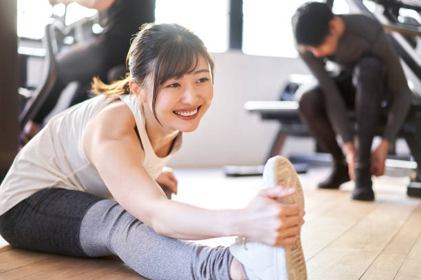 Asian woman stretching in a training gym Asian woman stretching in a training gym touching toes stock pictures, royalty-free photos & images