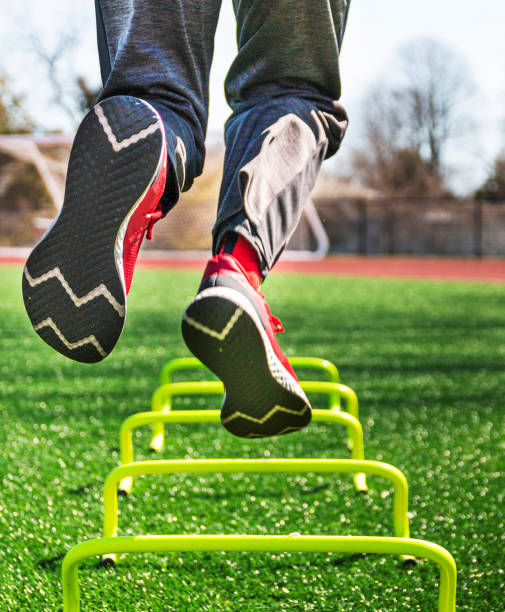 istock Athlete jumping on one leg over yellow six inch mini hurdles 1310426432