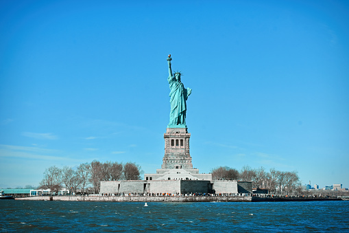 Statue of Liberty, colossal neoclassical sculpture and also known as Liberty Enlightening the World seen in a cruise on Hudson river, New York, USA