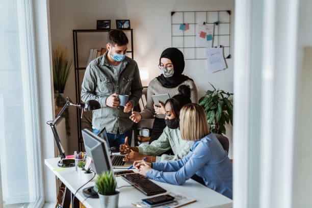 istock Teamwork in modern office during coronavirus pandemic 1310429199