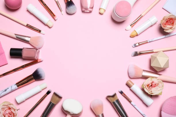 istock Frame of different makeup brushes, accessories and flowers on pink background, flat lay. Space for text 1310430332