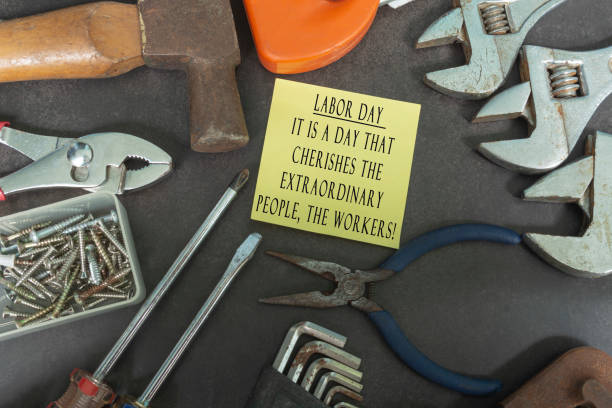 istock Text on yellow notepad with repair equipment and many handy tools on a dark background. Labor day concept 1310430803