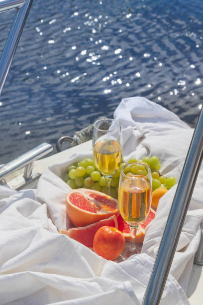 A pleasant stay for two on a white yacht. Fruit and wine are prepared for a delicious Breakfast. Warm water of a lake or river stock photo