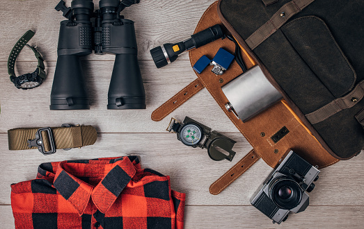 Hiking equipment concept on wooden background. Flat lay concept.