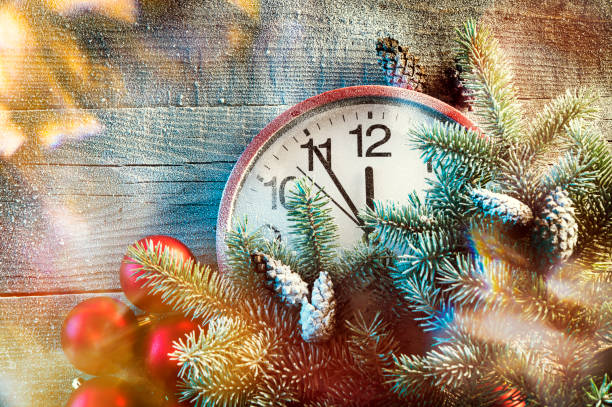 istock Red New Year clock with Christmas tree with cones on a wooden background 1310435410