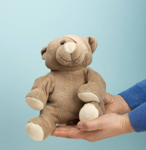 istock female hand hold a small brown toy teddy bear 1310439774