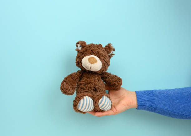 istock female hand hold a small brown toy teddy bear 1310441363