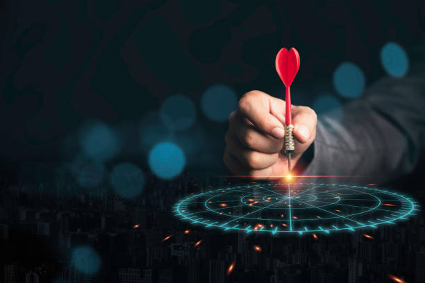 istock Businessman throwing red arrow dart to virtual target dart board. Setup objectives and target for business investment concept. 1310443762