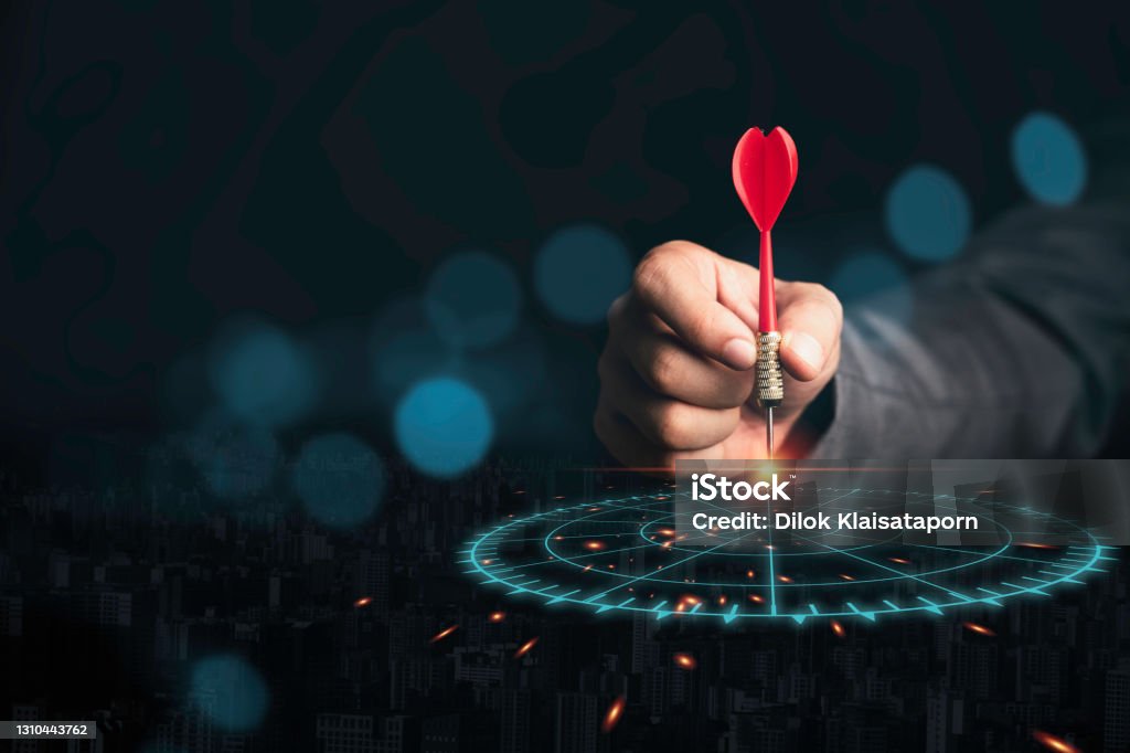 Businessman throwing red arrow dart to virtual target dart board. Setup objectives and target for business investment concept. Accuracy Stock Photo
