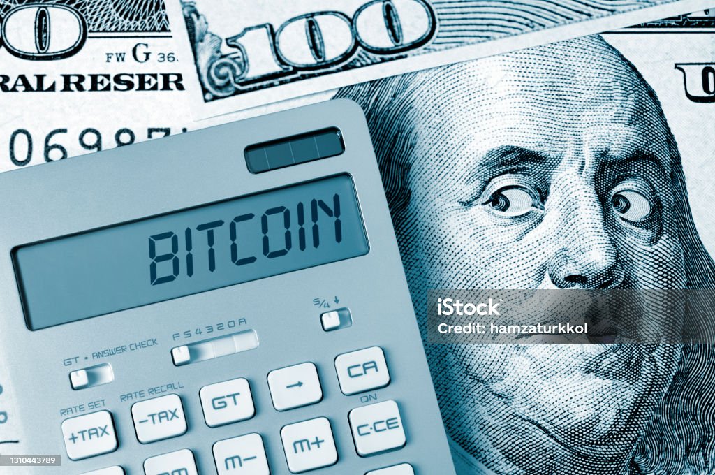 Ben Franklin's fear: Bitcoin Bitcoin. Benjamin Franklin looking calculator on One Hundred Dollar Bill. Bitcoin Stock Photo