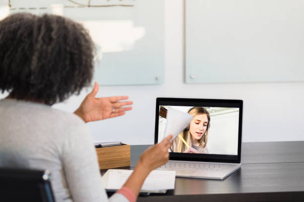 istock Mature teacher sits in classroom to tutor student via app 1310450528