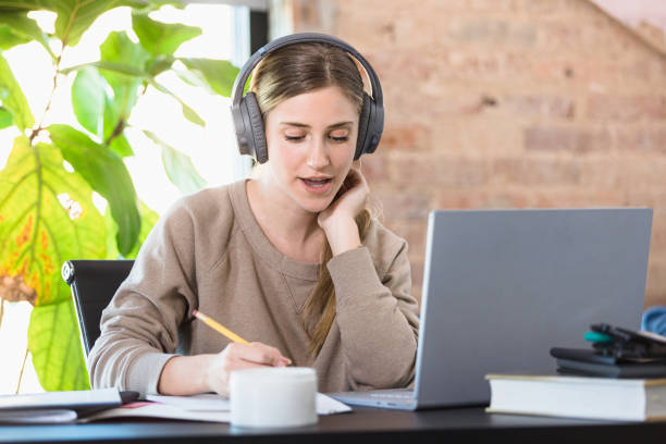 istock Sitting at home, the female student attends online class 1310450558