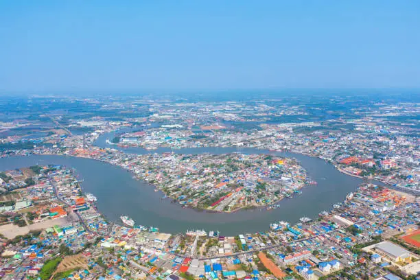 Photo of Aerial view of buildings with curve of Chao Phraya River. Samut Sakhon skyline near Bangkok, Urban city in downtown area at noon, Thailand.