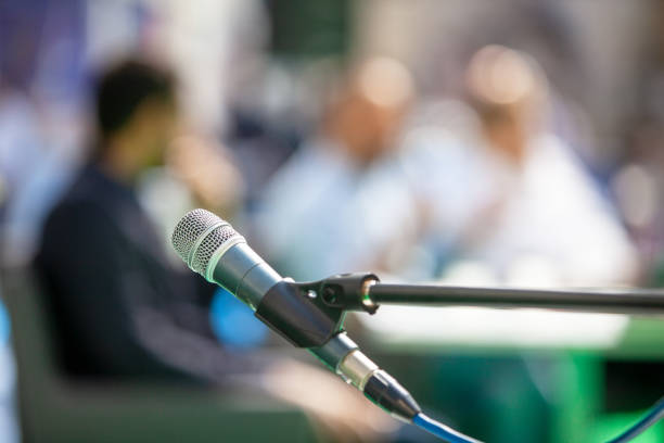 istock Microphone in focus against blurred people at roundtable event 1310455354