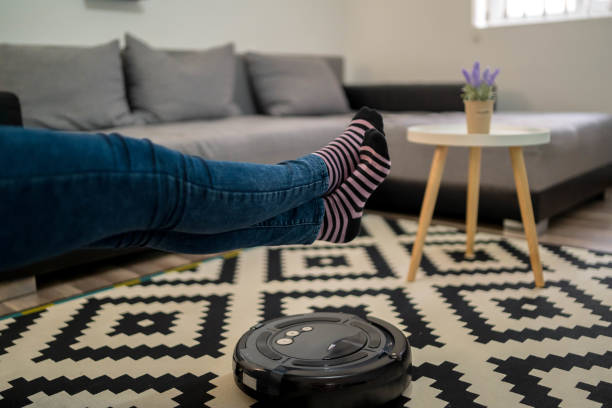 istock One woman, at home relaxing, while robot vacuum cleaner is working. 1310459449
