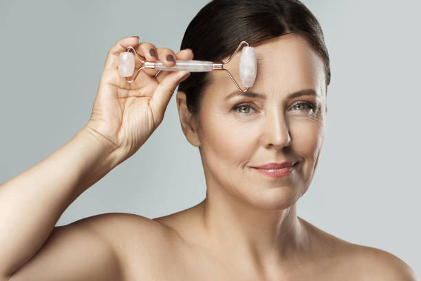 istock Beautiful middle aged woman using rose quartz derma roller 1310460600