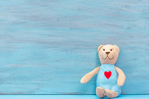 lindo osito de peluche en un fondo de madera azul - heart shape cute valentines day nostalgia fotografías e imágenes de stock