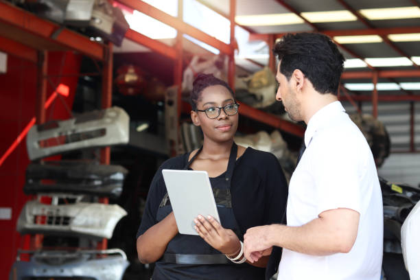 istock Happy harmony people at workplace, smiling white man and African American worker working together, two people checking product stock at auto spare parts store shop warehouse with many second hand engine parts as blurred background 1310462414