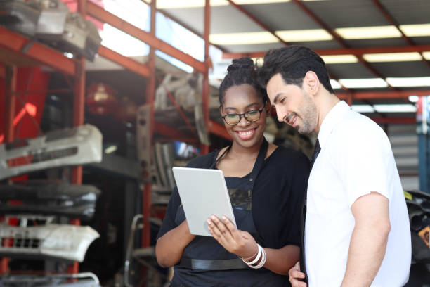 istock Happy harmony people at workplace, smiling white man and African American worker working together, two people checking product stock at auto spare parts store shop warehouse with many second hand engine parts as blurred background 1310462482