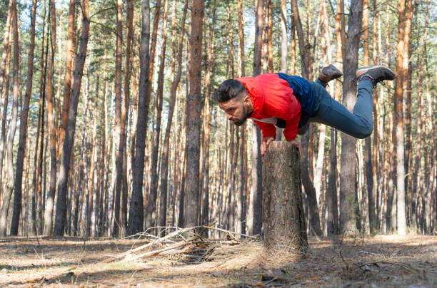 istock Pilates outdoors. Strong athletic man doing static strength exercises on a fresh air in the forest. 1310462638