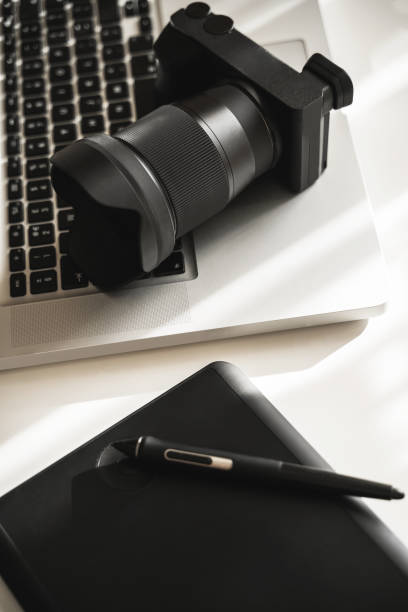 istock Photographer's workplace with a mirrorless camera, laptop and graphics tablet 1310462724