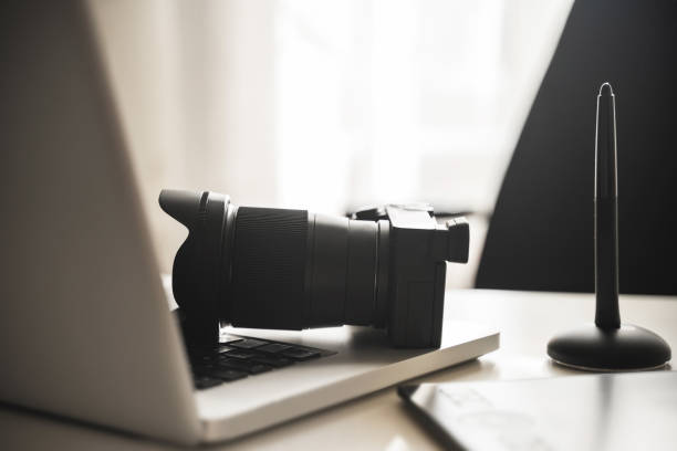 istock Photographer's workplace with a mirrorless camera, laptop and graphics tablet 1310463271