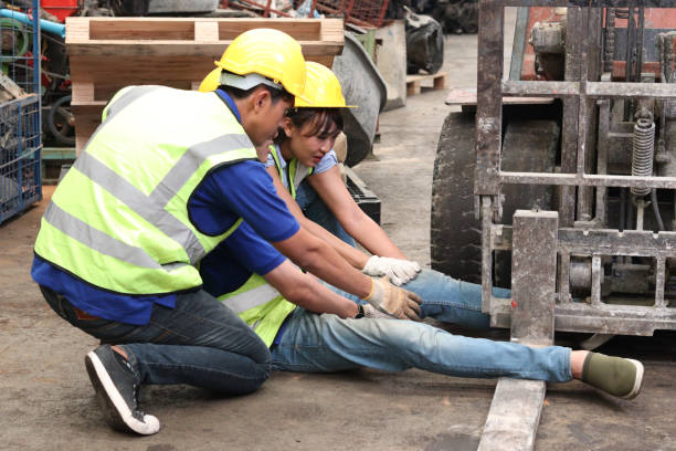 Accident at workplace, industrial engineer worker wearing helmet hit by forklift car at manufacturing plant factory construction site building, man leg stuck in forklift, colleague try to help him accidente en el lugar de trabajo, trabajador de ingeniería industrial con casco golpeado por carretilla elevadora en el edificio de construcción de la fábrica de fabricación, hombre pierna atrapada en la carretilla elevadora, colega tratar de ayudarle