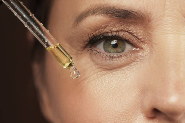female eye and dropper with rejuvenating serum - wrinkles eyes imagens e fotografias de stock
