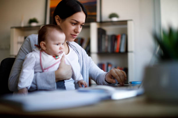 istock Mother holding her baby and working from home 1310463709