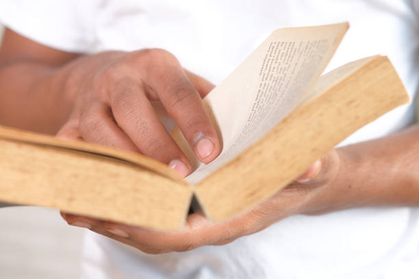 istock close up of person hand reading a book 1310464632