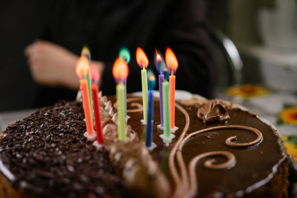 istock Chocolate birthday cake with candles, lighting candles on the cake. 1310468488